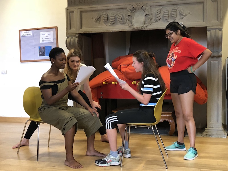 Commedia dell'Arte students doing scene work in the studio, holding scripts.